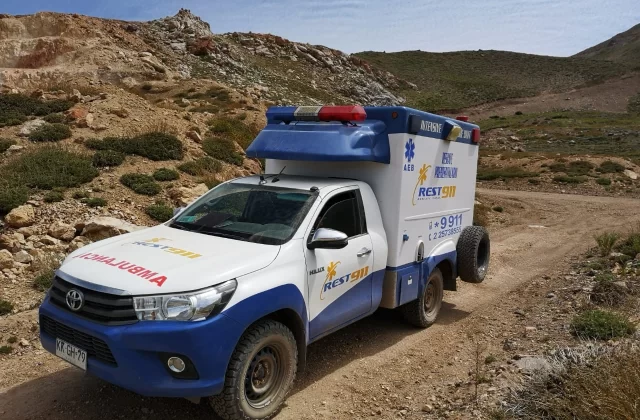 Ambulancia 4x4 REST911 en camino de tierra de una faena minera en la cordillera