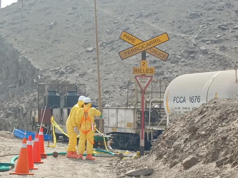 Equipo HAZMAT REST911 con trajes de protección química junto a un carro tanque